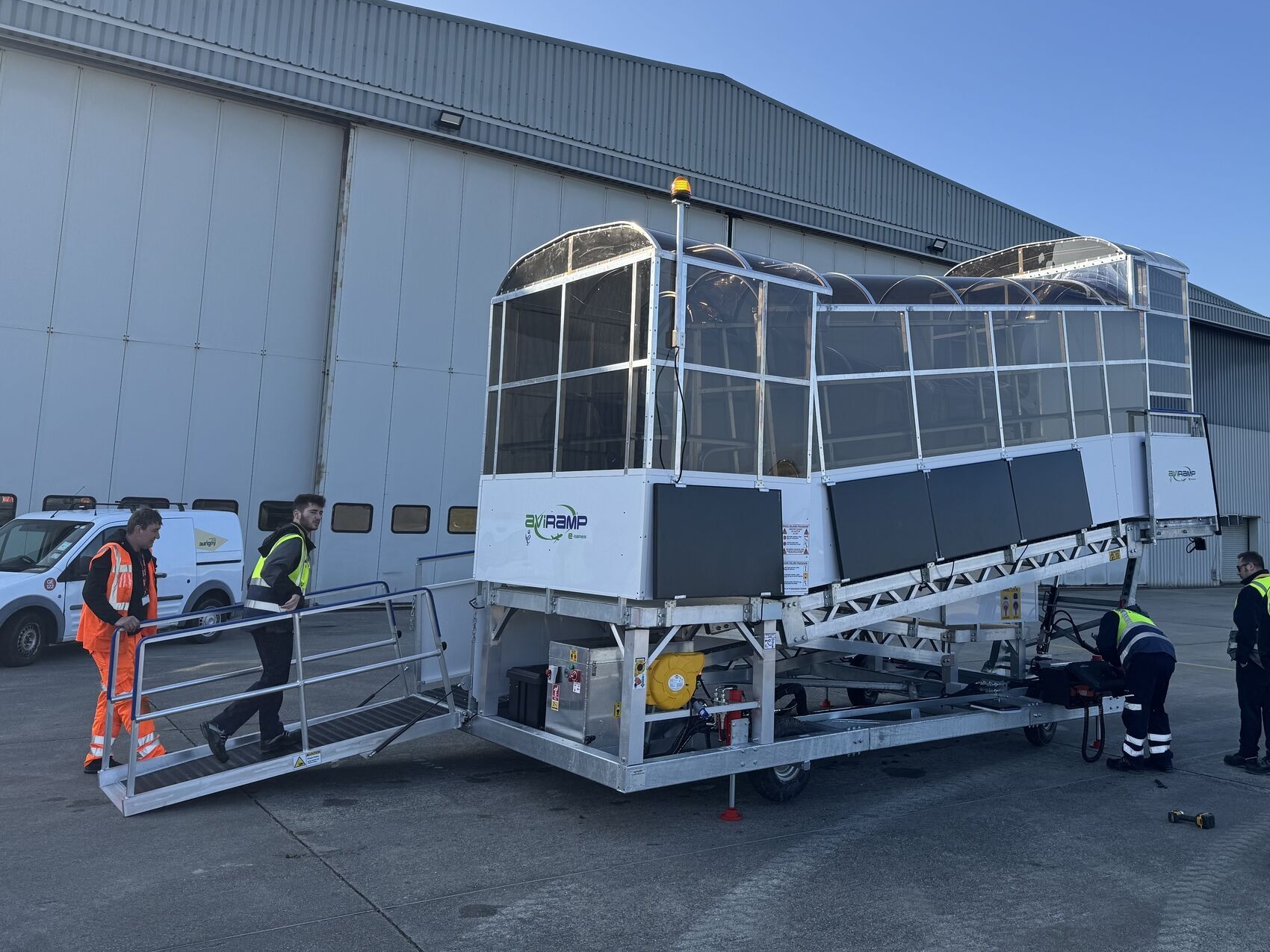 A glass passenger boarding bridge is being prepared at the airport, likely to facilitate passenger boarding and disembarkation for an aircraft. It highlights the airport's readiness for flight operations.