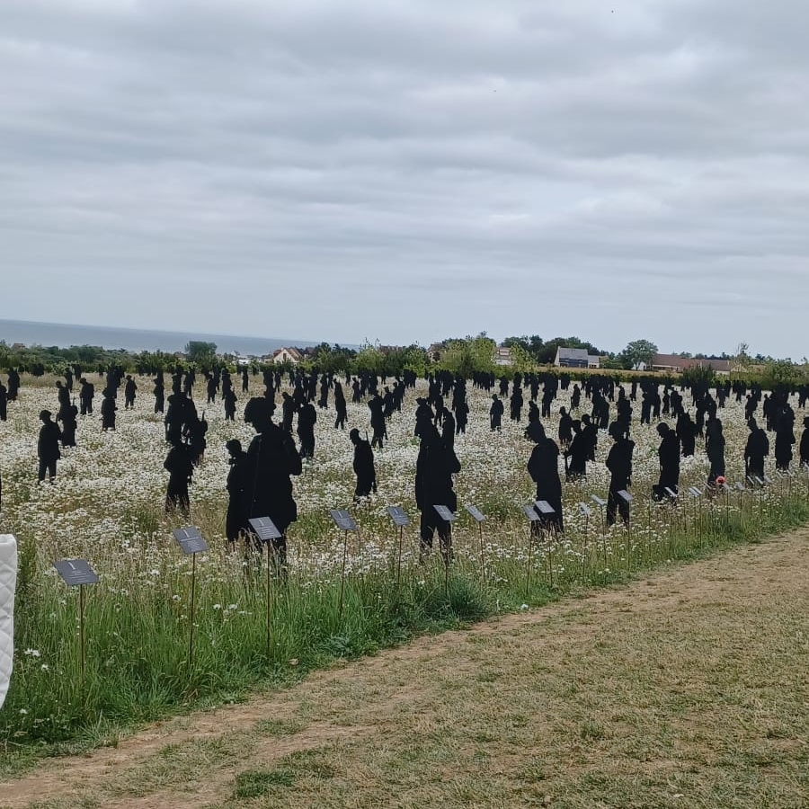 A moment of reflection: a small group gathered peacefully beneath a moody, overcast sky in an open landscape.