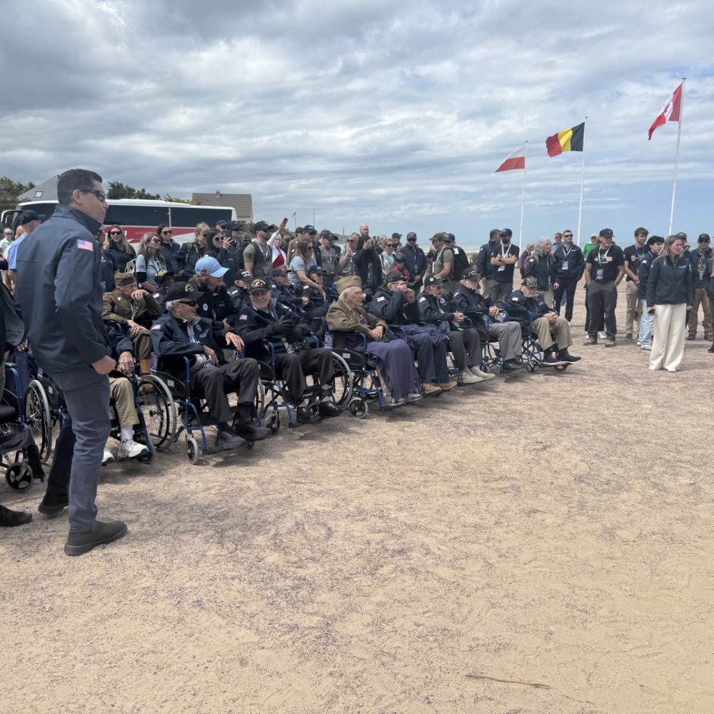 A solemn moment of remembrance as World War II veterans, joined by supporters and onlookers, commemorate the anniversary of the D-Day landings in Normandy—honouring the courage, sacrifice, and legacy of the Greatest Generation.