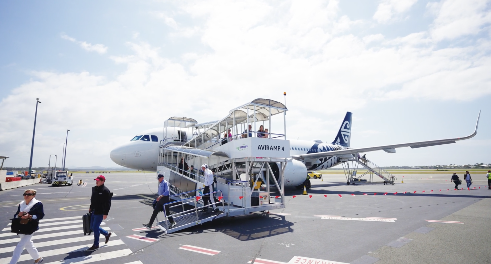 Passengers disembarking a plane at Sunshine Coast Airport using a step free Aviramp